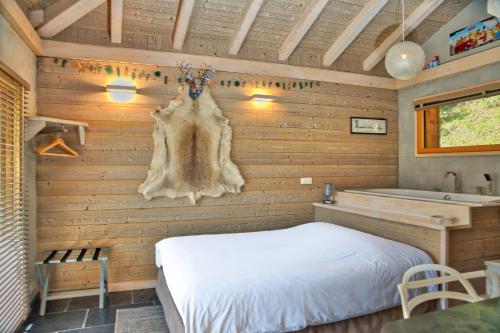 a room with a bed and a sink and a tub at Chalet dans les Arbres in Saint-Jean-d'Aulps