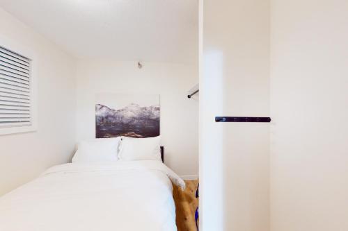 a bedroom with a bed and a painting on the wall at Snow Ghost Inn, Unit #311 in Big White