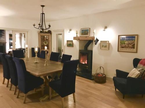 comedor con mesa, sillas y chimenea en Wild Atlantic Lodge, en Dunfanaghy