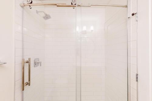 a shower with a glass door in a bathroom at Snow Ghost Inn, Unit #311 in Big White