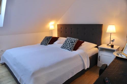 a bedroom with a large white bed with two pillows at Gut Basthorst in Basthorst