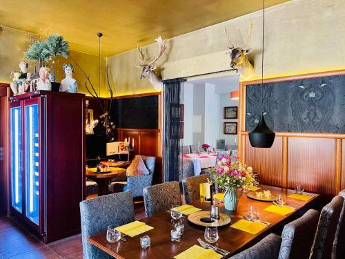 un restaurante con mesas, sillas y cabezas de ciervo en la pared en ZU DEN LINDEN - RADEBEUL Pension mit Restaurant, en Radebeul