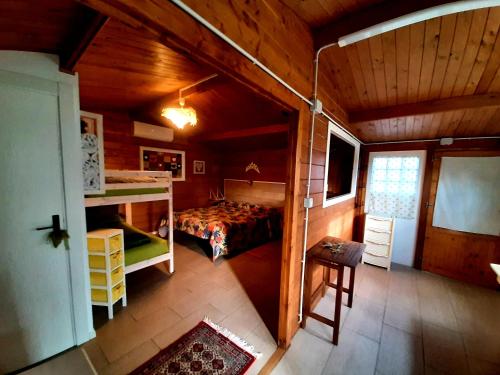 ein Schlafzimmer mit einem Bett in einer Holzhütte in der Unterkunft casa di campagna dal pozzo in Sorso