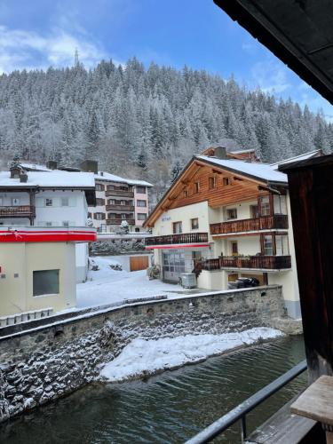 a view of a town with snow covered trees and a river at TOP LOCATION - Klosters center - 130m distance to ski lift Parsenn Gotschnabahn and railway station Klosters Platz - direct connection to Davos in Klosters