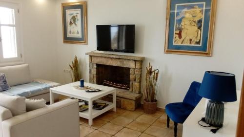 a living room with a couch and a tv on a fireplace at PRINCESS OF BLUE EAGLES RETREAT in Skaloma