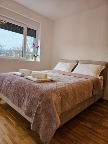 Vrnjačka Banja的住宿－Mimi，一间卧室配有一张大床和两条毛巾