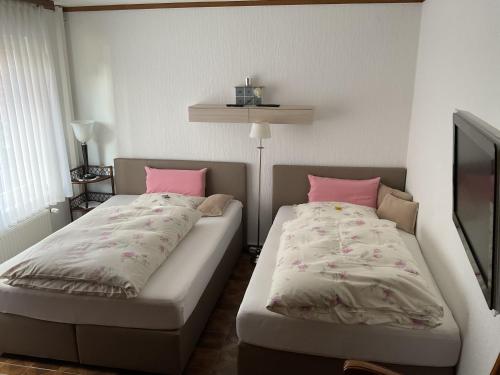 una camera con 2 letti con cuscini rosa di Fewo An der Mühlenbachaue a Nettetal