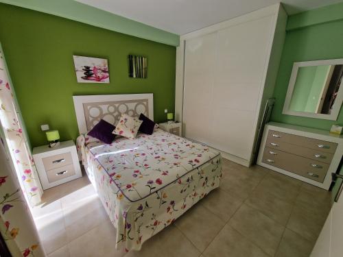 um quarto com uma cama e paredes verdes em Vera playa laguna beach em Vera