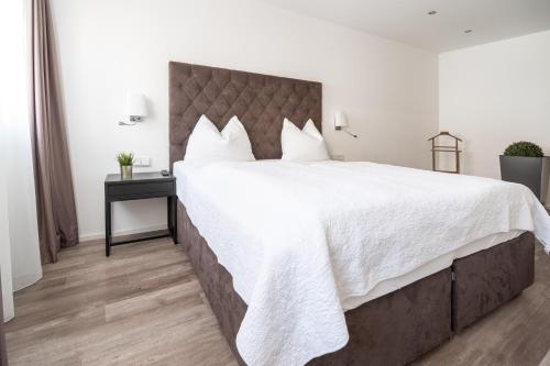 a large bedroom with a large bed with white sheets at Kaiser Max Design Appartements in Innsbruck