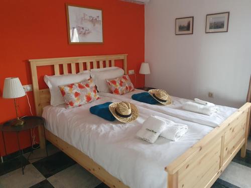 Casa Olivar B&B في Tocon: غرفة نوم بسرير كبير وعليه قبعات