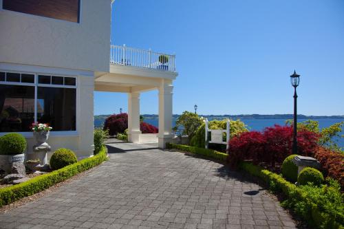 a walkway in front of a building with a view of the water at On The Point - Lake Rotorua in Rotorua