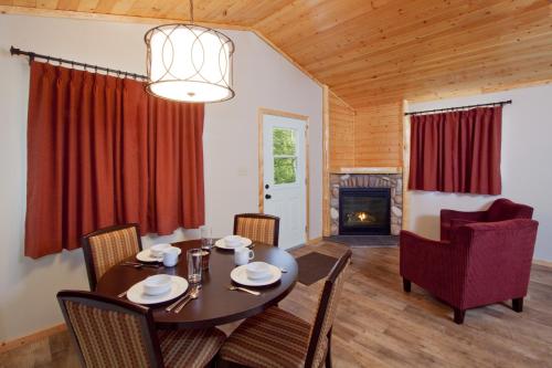 uma sala de jantar com uma mesa e cadeiras e uma lareira em Jasper East Cabins em Jasper