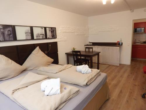 zwei Betten mit Handtüchern darauf in einem Zimmer mit Klavier in der Unterkunft FREE Apartment - Am Brühlbach in Bad Urach