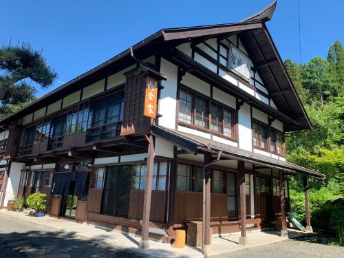 Un edificio con un orologio sul lato. di 宿屋白金家 yadoya-shiroganeya 1日1組限定2名から8名様まで 全館貸切り 伝統的建造物の旅籠宿 Traditional culture experience a Nagano