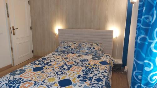 a bedroom with a bed with a blue and white comforter at AZULEJOS em VILAMOURA PORTUGAL in Vilamoura