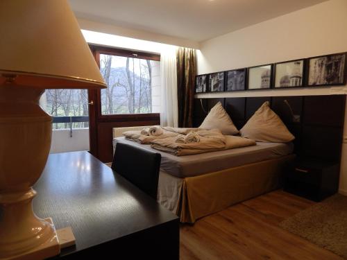 a bedroom with a bed and a table with a lamp at FREE Apartment - Am Brühlbach in Bad Urach