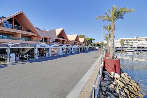 a street with a palm tree in front of a building at AZULEJOS em VILAMOURA PORTUGAL in Vilamoura