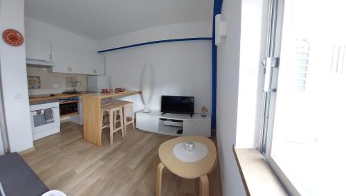 a small living room with a table and a kitchen at AZULEJOS em VILAMOURA PORTUGAL in Vilamoura