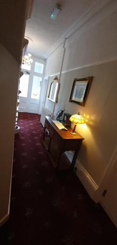 a hallway with a table and a lamp on a wall at The Westminster Hotel in Buxton