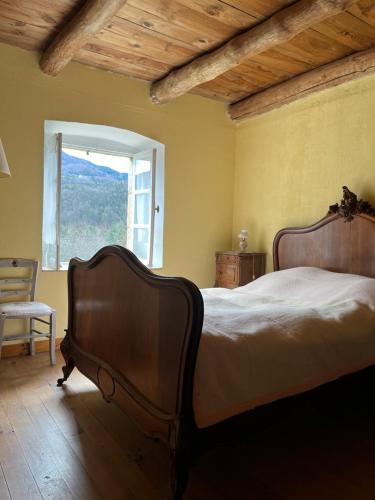 une chambre avec un lit, une fenêtre et une chaise dans l'établissement Retour dans la passé, à Roche-en-Régnier