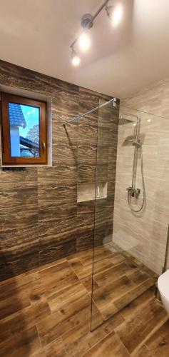 uma casa de banho com uma cabina de duche em vidro e um WC. em Apartamenty i Domki Mierzeja em Sztutowo
