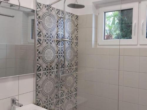 een douche met een glazen deur in de badkamer bij Nice Home in Maccagno con Pino e Veddasca with garden in Maccagno Inferiore