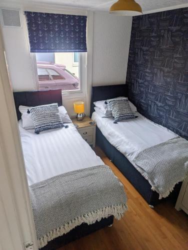 two beds in a small room with a window at Savannah-by-the-sea in Bridlington