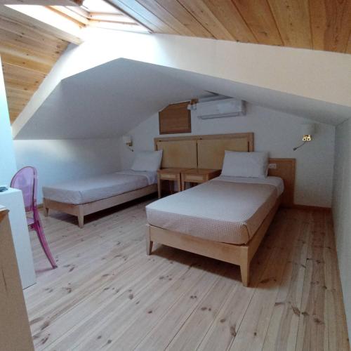 a attic room with two beds and a table at SITIA CITY CENTER luxury apartment in Sitia