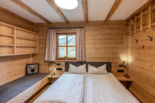 1 dormitorio con 1 cama grande en una habitación de madera en Pfefferkornhütte, en Warth am Arlberg