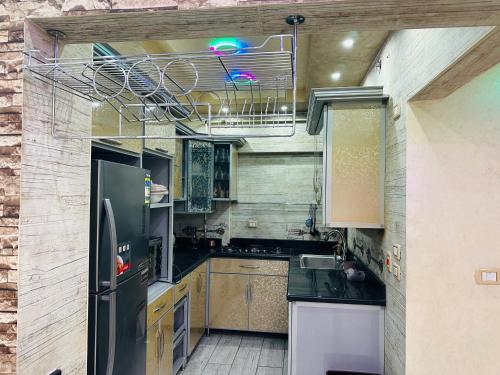 a kitchen with black counters and a refrigerator at 91 الميرلاند الدور 7 in Cairo