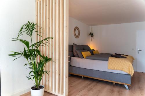 a bedroom with a bed and a potted plant at Green-Art-Living: NEW BOHO Style Central für 2 in Kempten