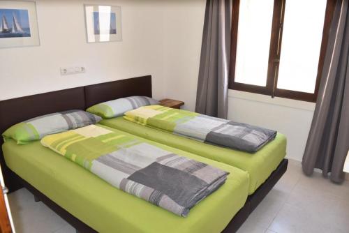 a bedroom with a large bed with green sheets at Casa Blanca Suiza in Benissa