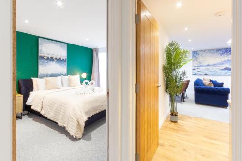 a bedroom with a bed and a green wall at Regent Grand Penthouse in Brighton & Hove