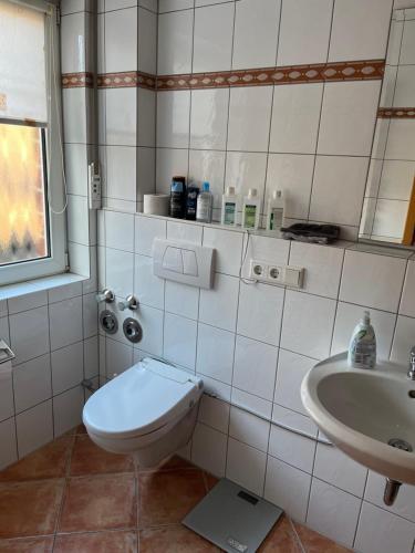Baño blanco con aseo y lavamanos en Nette Ferienwohnung nahe Düsseldorf, en Kaarst