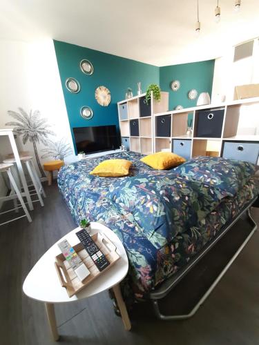 ein Schlafzimmer mit einem großen Bett und einem Tisch in der Unterkunft charmant studio Beauvais proche centre, gare , et aéroport. in Beauvais