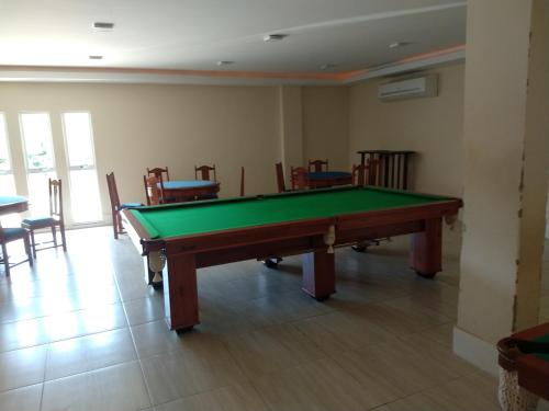 a pool table in a room with chairs at Apartamento no Golden Lake - pé na areia, agua de côco e cervejinha in Arraial do Cabo