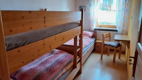 Łóżko piętrowe w niewielkim pokoju z krzesłem w obiekcie Moierhof w mieście Treffelstein
