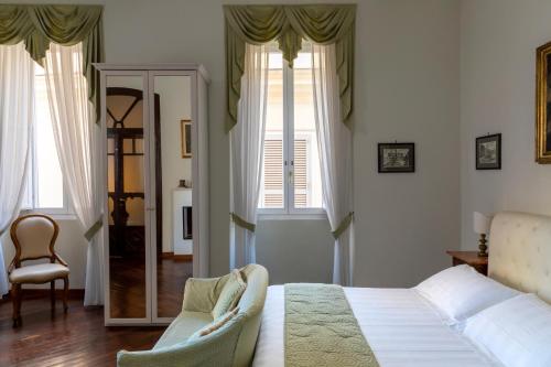 a bedroom with a bed and a chair and windows at Hotel Scalinata Di Spagna in Rome