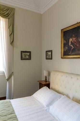 a bedroom with a white bed and a painting on the wall at Hotel Scalinata Di Spagna in Rome