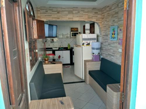 una piccola cucina con divano e frigorifero di Residencialpinheiro (apto 2) a Porto De Galinhas