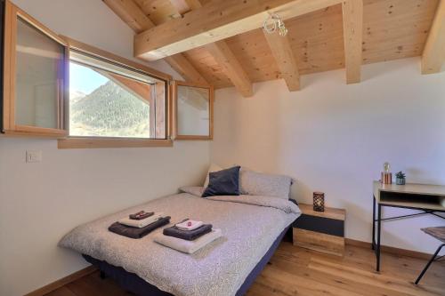 1 dormitorio con cama, escritorio y ventana en B&B Bagnes, en Versegeres 