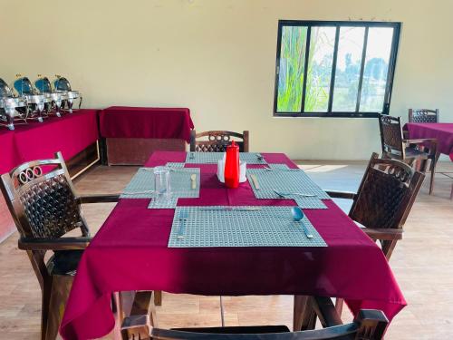 a dining room with a table with a purple table cloth at Hotel Happy Land in Chitwan