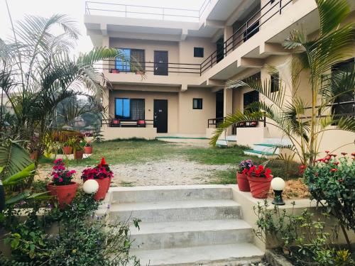 a building with stairs and flowers in pots at Hotel Happy Land in Chitwan
