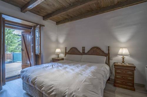 ein Schlafzimmer mit einem Bett und zwei Nachttischen mit Lampen in der Unterkunft Apartamento a pie de pistas en el Tarter in El Tarter