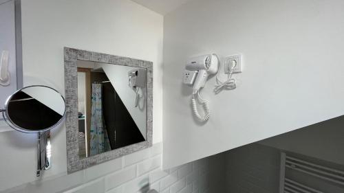 a bathroom with a mirror and a phone on a wall at Charlie&Blueberries in Belgrade