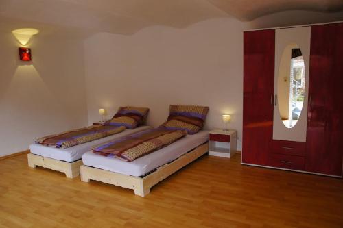 a bedroom with two beds and a mirror at Worthwhile-Days FeWo Kleinschwabhausen in Kleinschwabhausen