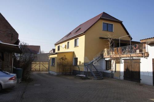 a yellow house with a staircase next to a street at Worthwhile-Days FeWo Kleinschwabhausen in Kleinschwabhausen