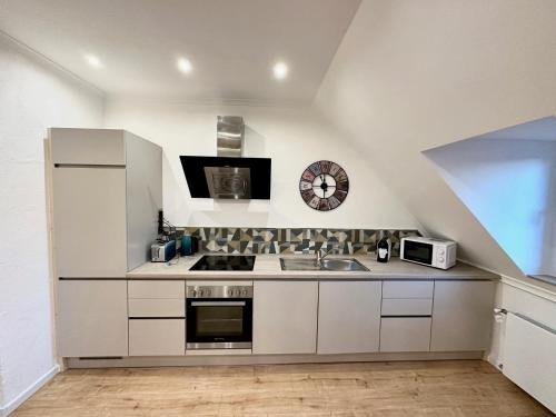 cocina blanca con fregadero y microondas en Stadthaus Apartment Bachperle, en Mayen