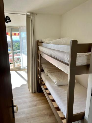 une chambre avec deux lits superposés et une fenêtre dans l'établissement Les Capitelles 97 - Studio vue mer - residence avec piscine - Wifi - Parking, à Saint-Cyprien