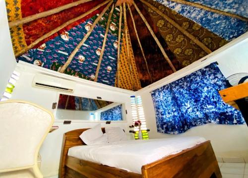 a room with a bed and a ceiling withpired at Le BASTA in Ouagadougou